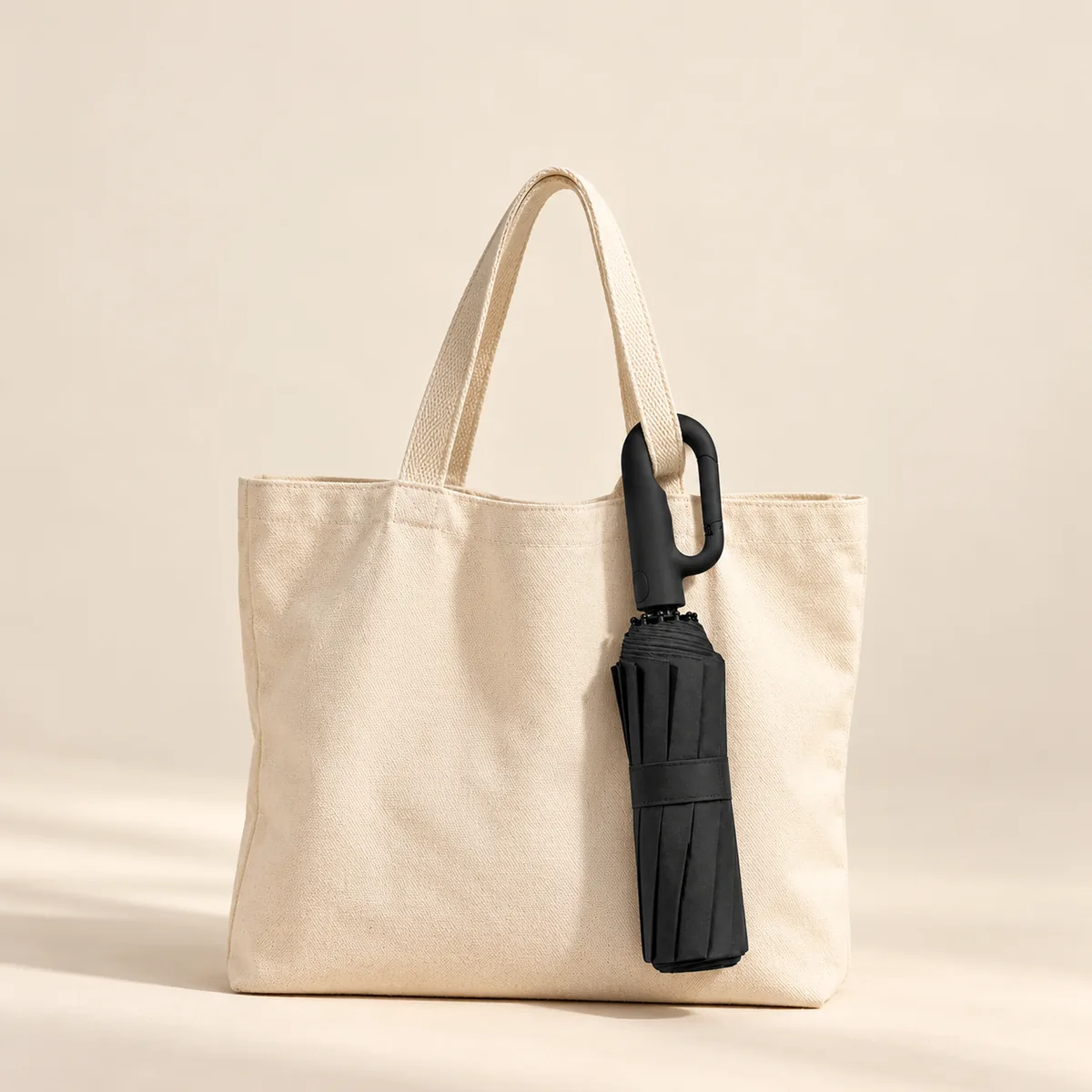 Haven Umbrella clipped to a canvas tote bag by its carabiner handle